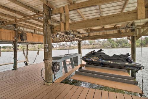 a boat sitting on a dock on the water at Waterfront San Jacinto River Home with Boat Slip! in Houston