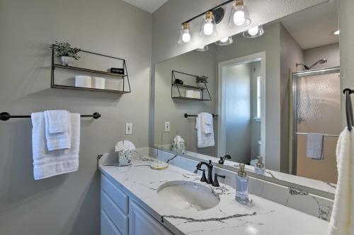 Un baño con lavabo y un espejo grande. en West Galveston Home about Steps from Terramar Beach!, en Galveston