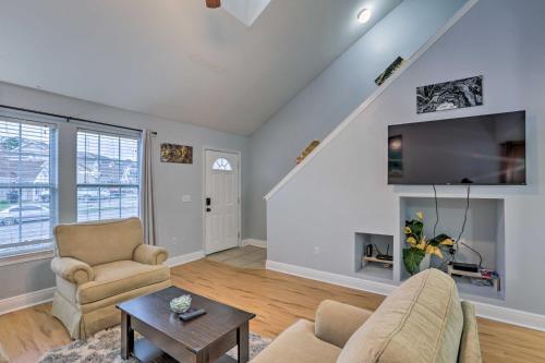 a living room with a couch and a tv at Tidy Tallahassee Townhome about 7 Mi to Downtown! in Tallahassee