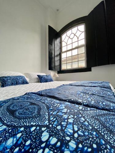 a bedroom with two beds and a window at Pousada Bartholomeu in Paraty
