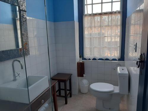 a bathroom with a toilet and a sink and a shower at Pousada Bartholomeu in Paraty