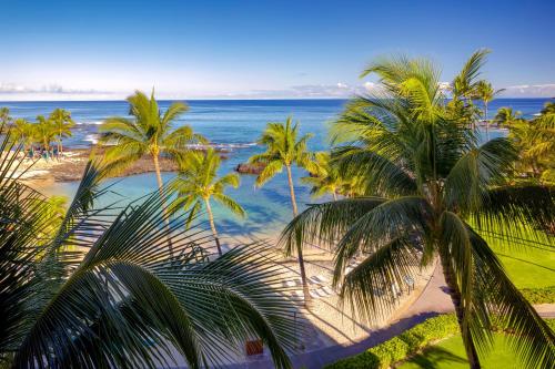 a view of a beach with palm trees and the ocean at Fairmont Orchid in Waikoloa