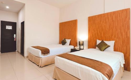 a hotel room with two beds in it at Saka Hotel Medan in Sunggal