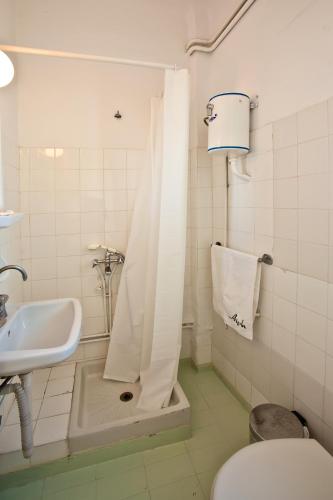 a bathroom with a shower and a sink and a toilet at Aegli 1876 in Tinos Town