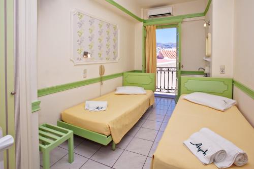 two beds in a room with a balcony at Aegli 1876 in Tinos Town
