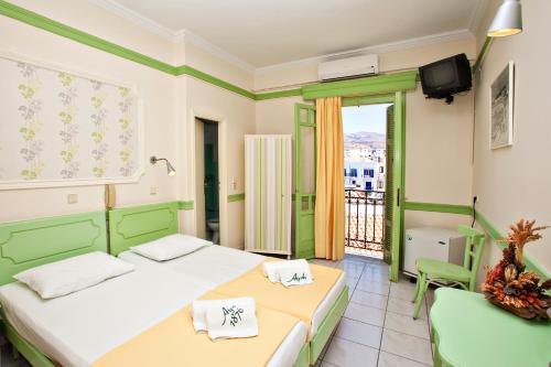 a hotel room with two beds and a balcony at Aegli 1876 in Tinos Town