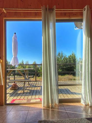 a large window with a view of a deck at Cabañas Refugio Las Conejas in Pelluhue