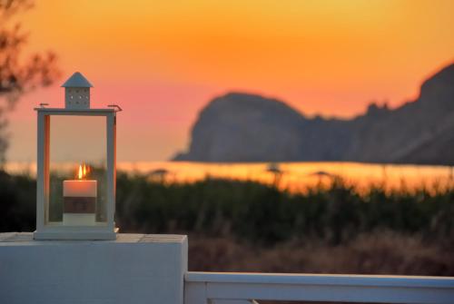 a candle on a table with the sunset in the background at Hotel Benois in Galissas
