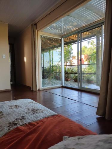 ロチャにあるNaturaleza puraのベッドルーム1室(ベッド1台付)、大きなスライド式ガラスドアが備わります。