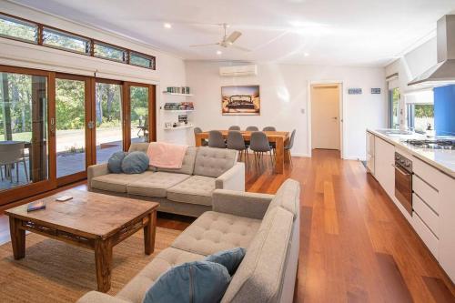 a living room with a couch and a table at Blue Haven Margaret River tranquil bush retreat in Margaret River Town