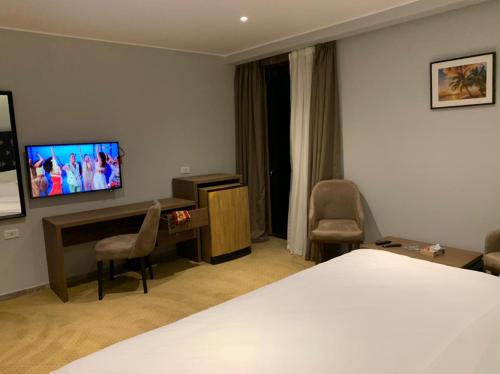 a hotel room with a bed and a flat screen tv at Point 11 Residence in Dumyāţ