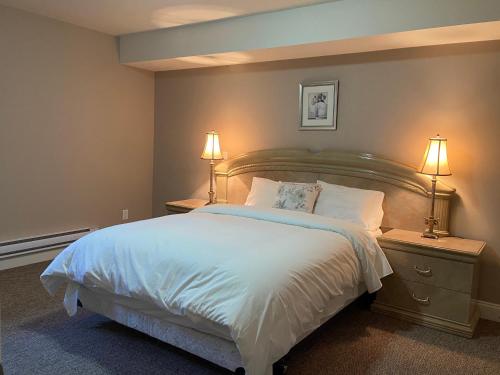 1 dormitorio con 1 cama grande y 2 lámparas en Mae Sweet Home, en Surrey