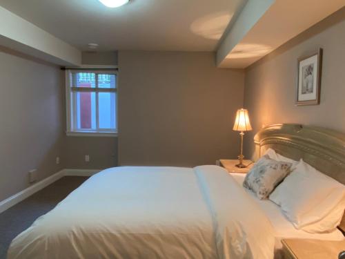 a bedroom with a large white bed with a window at Mae Sweet Home in Surrey