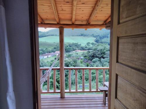 a door leading to a balcony with a view at Hospedagem Colinas Chalé 2 in Aiuruoca