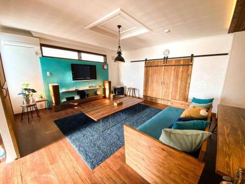 a living room with a blue couch and a television at Poroto Base ウポポイまで徒歩2分 in Shiraoi