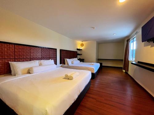 a hotel room with two beds and a television at M Season Boutique Hotel Sdn Bhd in Sungai Petani