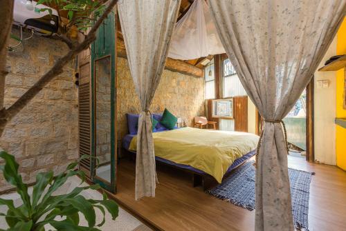 1 dormitorio con 1 cama en una habitación en The Kadupul Homecation, en Da Lat