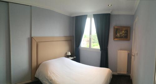 a bedroom with a white bed and a window at Hôtel Saint Alban in Saint-Maur-des-Fossés