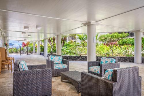 a covered porch with chairs and a table at Aston Kona By The Sea in Kailua-Kona