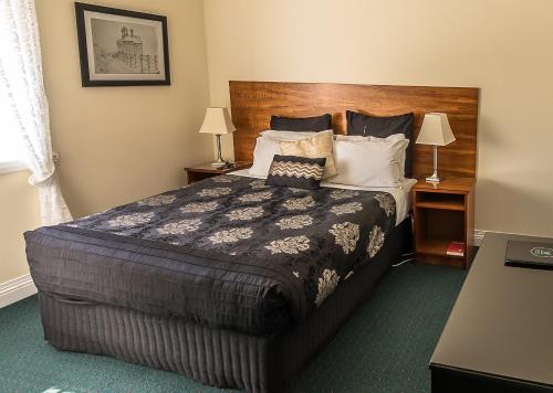 a bedroom with a large bed with a wooden headboard at Stanley Hotel in Stanley