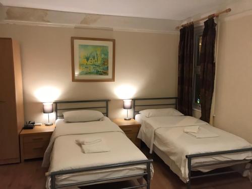 two beds in a hotel room with two lamps at Atlas Oxford House in Oxford