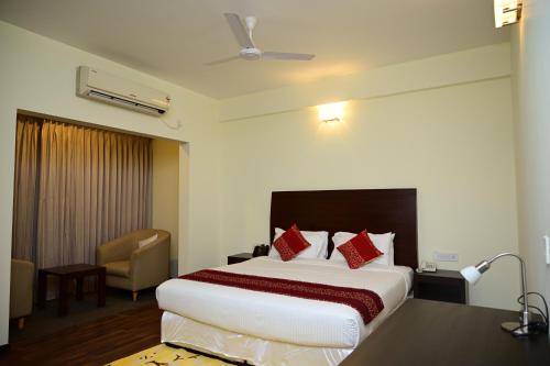 a hotel room with a large bed and a chair at Sterling Keys by TGI in Bangalore