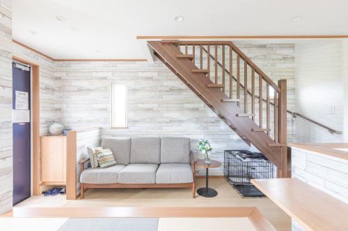 a living room with a couch and a staircase at Seaside House Yasutaketei in Shirahama