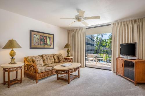 a living room with a couch and a tv at Aston Kona By The Sea in Kailua-Kona
