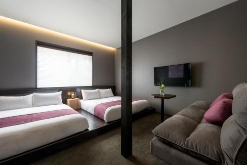 a hotel room with two beds and a couch at THE MACHIYA HOTEL TAKAYAMA in Takayama