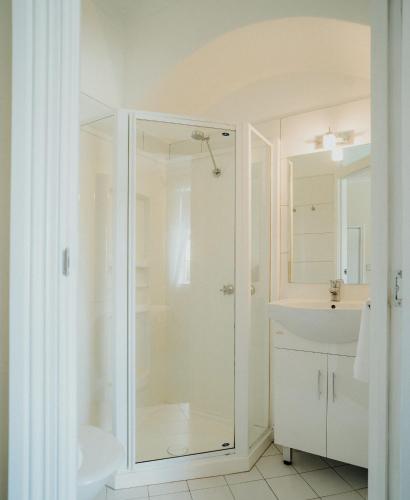 a white bathroom with a shower and a sink at Stanley Hotel in Stanley