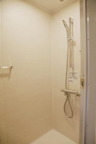 a shower in a bathroom with a hose at ibis Osaka Umeda in Osaka
