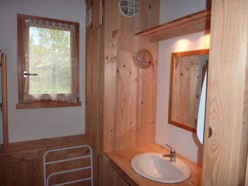 ein Bad mit einem Waschbecken und einem Spiegel in der Unterkunft Lovely chalet in Vosges with shared pool in Zhezdi