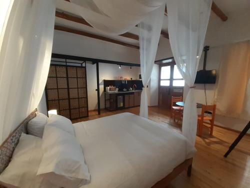 a bedroom with a large bed with white curtains at Hostal Suite Le Fabrique in Cuenca