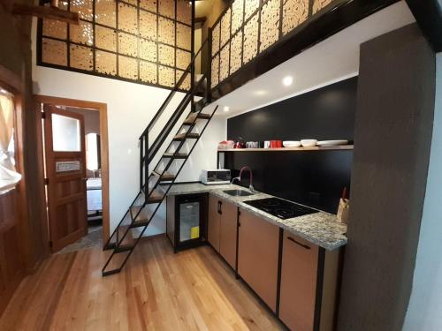 a kitchen with a loft conversion with a staircase at Hostal Suite Le Fabrique in Cuenca