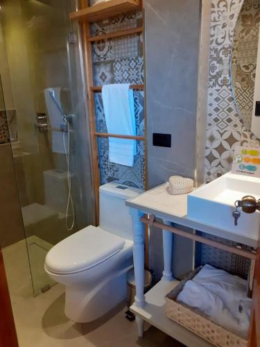 a bathroom with a toilet and a sink and a shower at Hostal Suite Le Fabrique in Cuenca