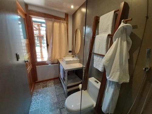a bathroom with a toilet and a sink and a mirror at Hostal Suite Le Fabrique in Cuenca