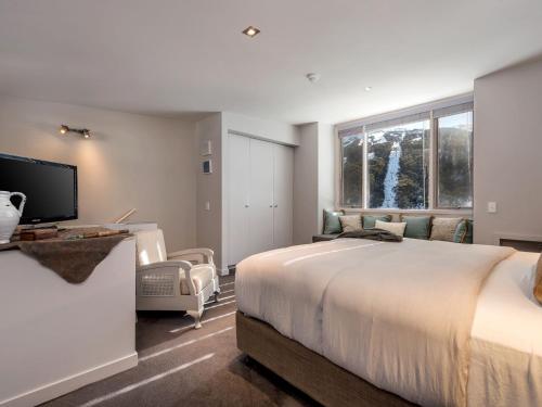 a bedroom with a large bed and a large window at Big Nanook Squatters 32 in Thredbo