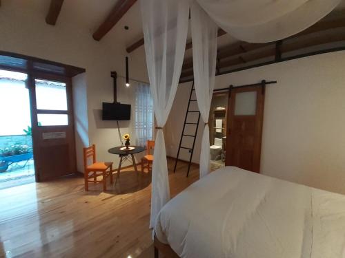 a bedroom with a bed and a table and chairs at Hostal Suite Le Fabrique in Cuenca