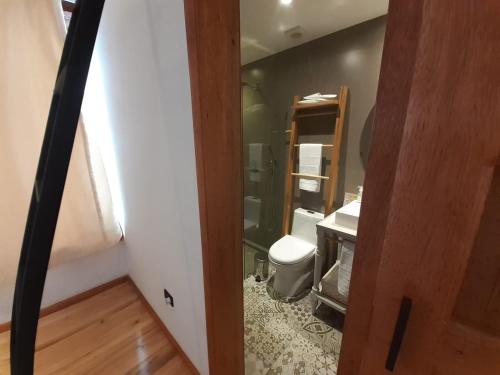 a bathroom with a toilet and a sink at Hostal Suite Le Fabrique in Cuenca