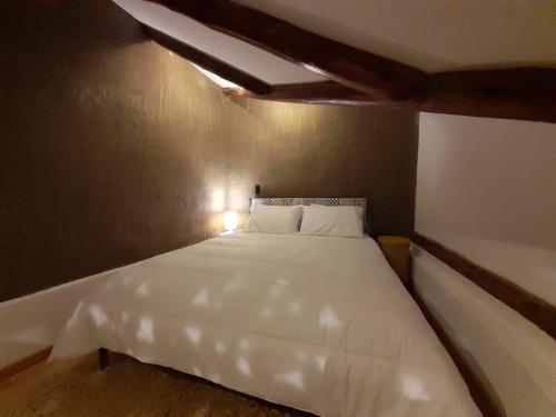 a bedroom with a large white bed in a room at Hostal Suite Le Fabrique in Cuenca