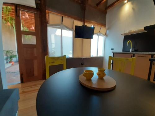 a kitchen with a black table with two cups on it at Hostal Suite Le Fabrique in Cuenca
