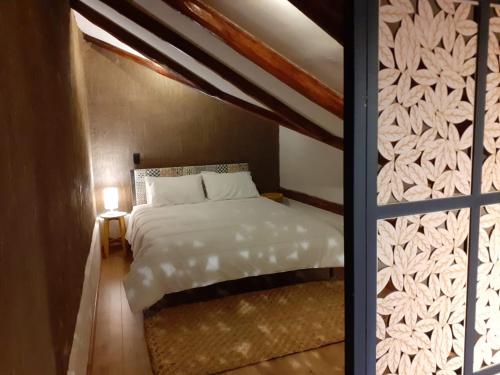 a bedroom with a white bed and a window at Hostal Suite Le Fabrique in Cuenca