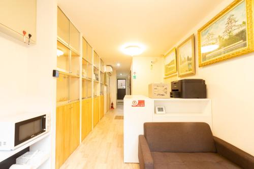 korytarzem pokoju z kanapą i telewizorem w obiekcie 民泊 古 w Osace