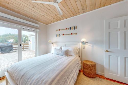 um quarto com uma cama e uma porta de vidro deslizante em Portside em Boothbay Harbor