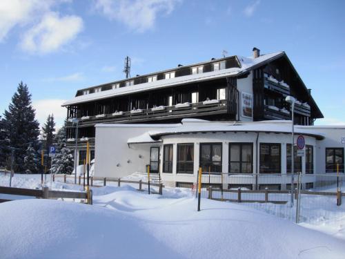 a building in the snow with a pile of snow at Hotel Dolomiti Chalet in Vason