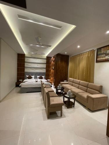 Habitación de hotel con cama, sofá y mesas en Maheshwari jalsa, en Kota