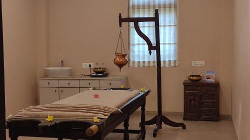 a room with a bed and a sink and a table at juSTa Rudra Resort & Spa in Kolād