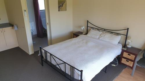 a bedroom with a large bed with white sheets and pillows at Bahara Accommodation in Springfield