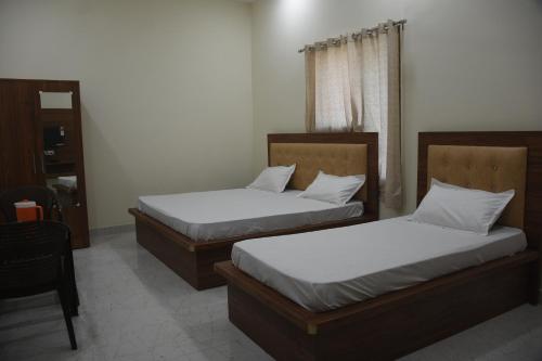 two beds in a room with at GURU KRIPA GARDEN in Govardhan