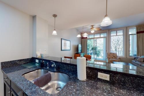 a kitchen with a sink and a living room at Baytowne Wharf - Observation Point North #555 in Destin